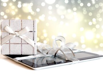 Tablet z prezentem świątecznym na rozmytych światłach