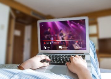 Koncepcja strumieniowego przesyłania wideo online. Kobieta oglądająca teledysk na laptopie w domu