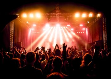 koncert rockowy, sylwetki szczęśliwych ludzi podnoszących ręce